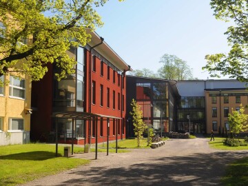 Raseborgs campusområde, vårbild med gröna träd och solljus