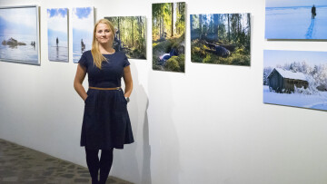 Anni Laukka framför hennes fotografier
