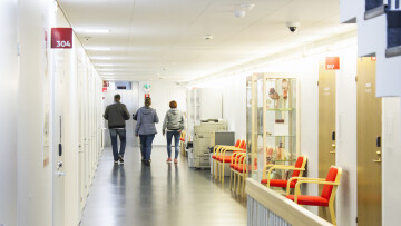 tre personer i slutet av en korridor