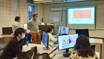 studerande som jobbar i datasal med ansiktsskydd