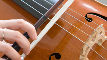 person spelar på en cello