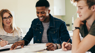 Tre personer sitter vid ett bord