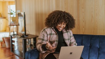 person, kvinna, med dator i famnen. 