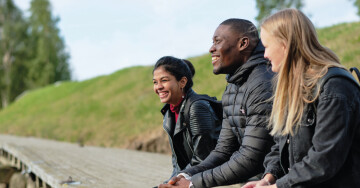 Tre studerande på brygga