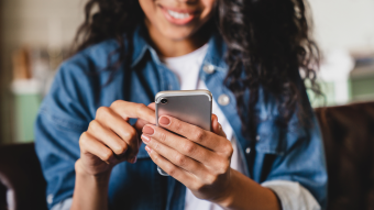 Ung kvinna som håller i en telefon