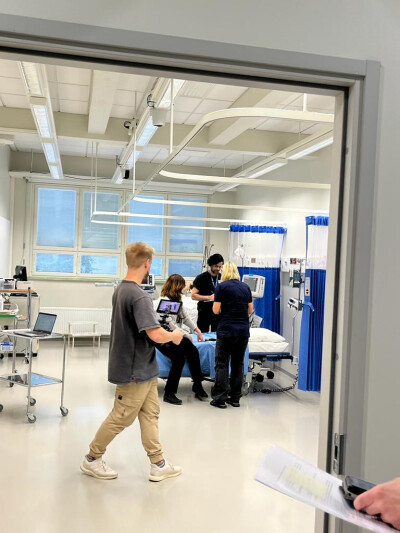 Person filming a medical scenario in a hospital-like environment