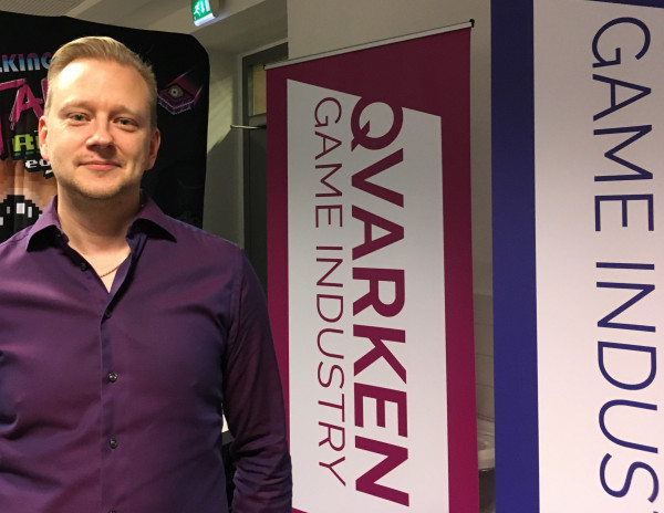 En man som ler och ser in i kameran.