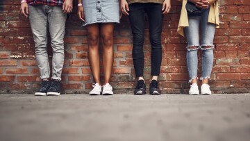 personer som står på rad längs med en vägg, endast benen syns