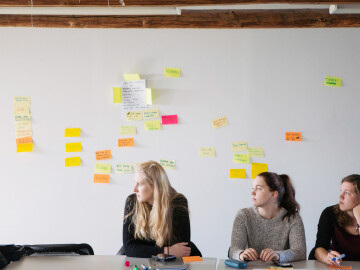 Företagsekonomi studerande framför post-it-tavla